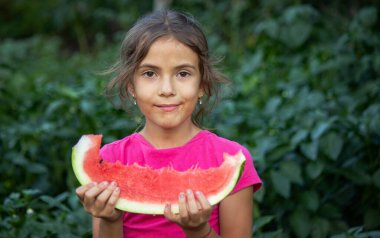Küçük kız bahçede sağlıklı organik karpuz yiyor..