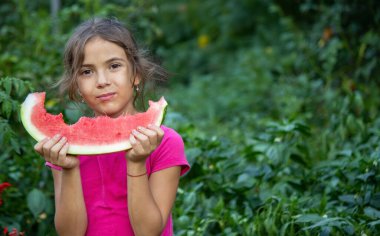Küçük kız bahçede sağlıklı organik karpuz yiyor..