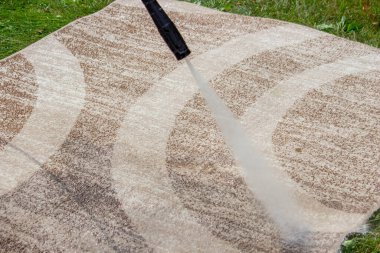 Yüksek basınçlı bir çamaşır makinesiyle halıyı yıkamak. Seçici odak.