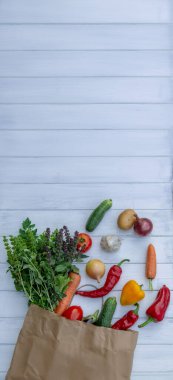 Beyaz ahşap arka planda taze sebzeler ve kese kağıdı. Seçici odak.