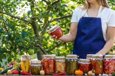 Doğanın arka planında salatalık konservesi yapan bir kadın. Seçici odak.