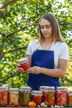 Doğanın arka planında salatalık konservesi yapan bir kadın. Seçici odak.