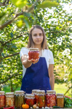 Doğanın arka planında salatalık konservesi yapan bir kadın. Seçici odak.