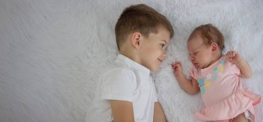 Bir erkek kardeş küçük kız kardeşini öper. Bir ağabey ve yeni doğmuş bir kız.