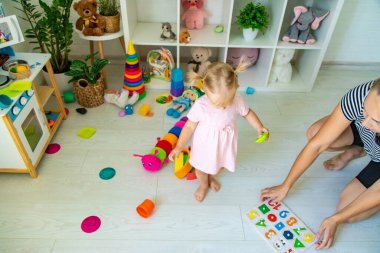 Küçük kız oyuncaklarla oynuyor. Seçici odak.