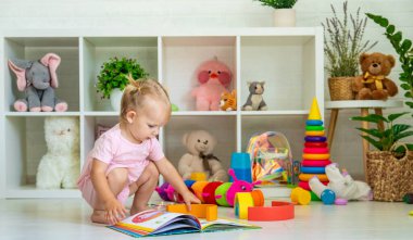 Küçük kız oyuncaklarla oynuyor. Seçici odak.