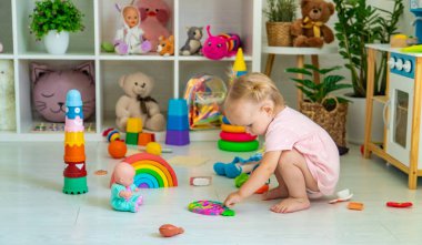 Küçük kız oyuncaklarla oynuyor. Seçici odak.