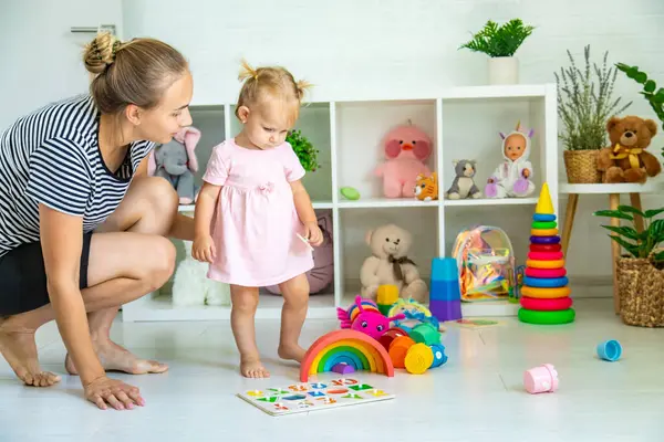 Küçük kız oyuncaklarla oynuyor. Seçici odak.