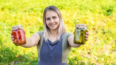 Bir kadın kavanozlarda sebze saklar. Seçici odak.