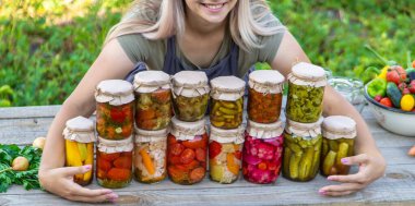 Bir kadın kavanozlarda sebze saklar. Seçici odak