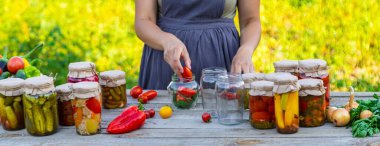 Bir kadın kavanozlarda sebze saklar. Seçici odak