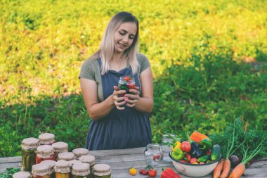 Bir kadın kavanozlarda sebze saklar. Seçici odak