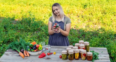 Bir kadın kavanozlarda sebze saklar. Seçici odak