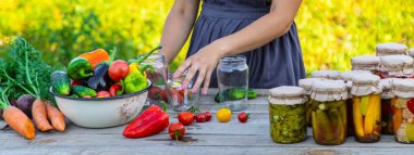 Bir kadın kavanozlarda sebze saklar. Seçici odak