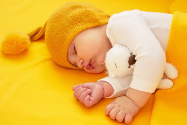 Bebek sarı arka planda uyuyor. Seçici odak.
