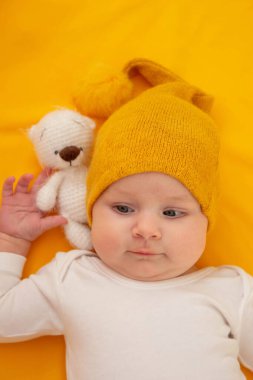 Sarı arka planda yatan gülümseyen bebek. Bebeğim.