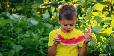 Çocuk yazın karpuz yer. Seçici odak.