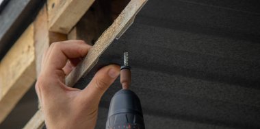 Bir matkapla Çatı Panelleri Yükleniyor.