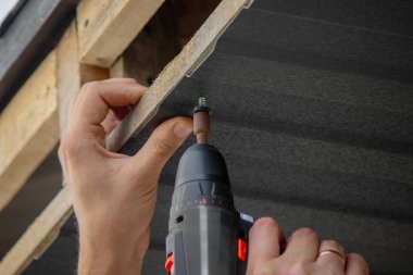 Bir matkapla Çatı Panelleri Yükleniyor.