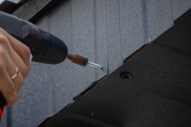 Bir matkapla Çatı Panelleri Yükleniyor.