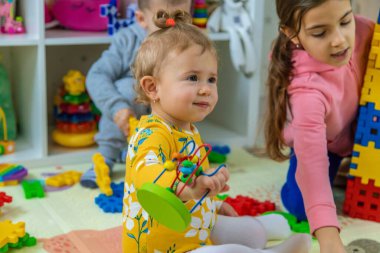 Çocuklar odada oyuncaklarla oynuyorlar. Seçici odak.