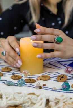 Woman fortune teller fortune telling on a candle. Selective focus. people.