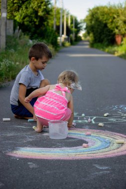 Çocuk asfalta tebeşirle çizer. Seçici odaklanma. Çocuk.