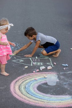 Çocuk asfalta tebeşirle çizer. Seçici odaklanma. Çocuk.
