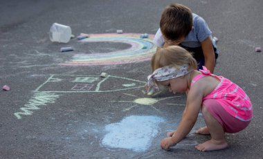 Çocuk asfalta tebeşirle çizer. Seçici odaklanma. Çocuk.