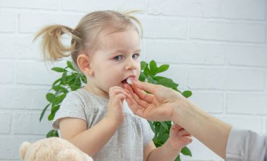 Kadın doktor küçük kıza vitamin ya da askorbik veriyor. Çocuk doktorunun ataması, sağlık konsepti