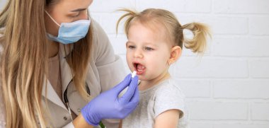 Kadın doktor küçük kıza vitamin ya da askorbik veriyor. Çocuk doktorunun ataması, sağlık konsepti