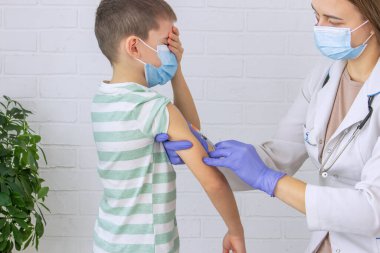 Doktor bir çocuğa aşı yapıyor, bir çocuğa. Çocuk doktorunun ataması, sağlık konsepti.
