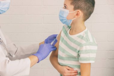 Doktor bir çocuğa aşı yapıyor, bir çocuğa. Çocuk doktorunun ataması, sağlık konsepti.