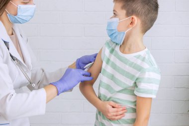 Doktor bir çocuğa aşı yapıyor, bir çocuğa. Çocuk doktorunun ataması, sağlık konsepti.