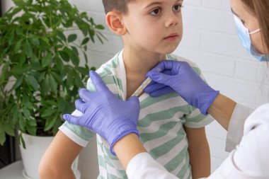 Doktor randevusundaki çocuk ateşini ölçüyor. Çocuk doktorunun ataması, sağlık konsepti.