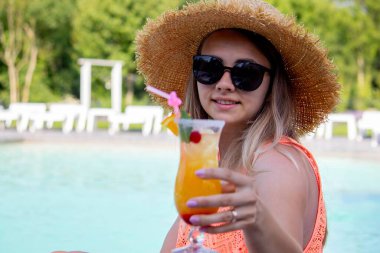 Havuzun yanında kokteyl içen kadın.
