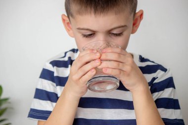 Çocuk bardaktan su içiyor. Seçici odak.