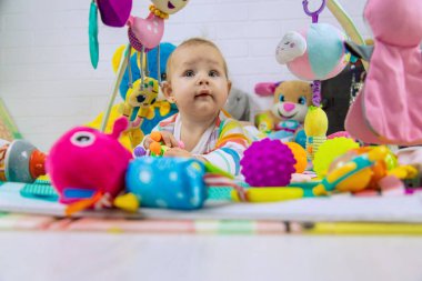 Bebek oyuncak paspasın üzerinde oynuyor. Eğitici oyuncağı olan bir çocuk. Erken gelişme.
