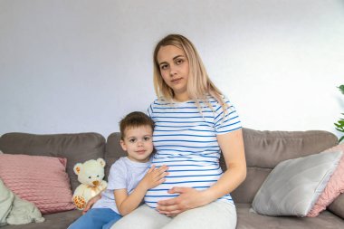 Hamile bir kadın en büyük oğluna sarılır. Seçici odaklanma. Aşk.