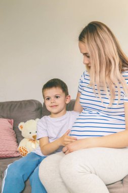 Hamile bir kadın en büyük oğluna sarılır. Seçici odaklanma. Aşk.