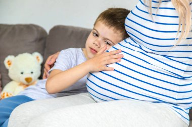 Hamile bir kadın en büyük oğluna sarılır. Seçici odaklanma. Aşk.