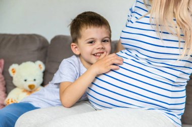 Hamile bir kadın en büyük oğluna sarılır. Seçici odaklanma. Aşk.