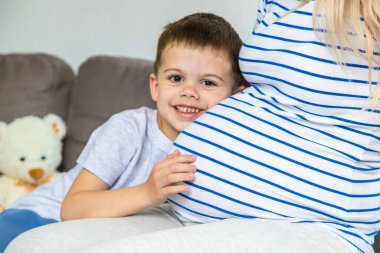 Hamile bir kadın en büyük oğluna sarılır. Seçici odaklanma. Aşk.