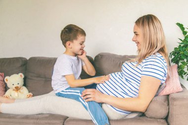 Hamile bir kadın en büyük oğluna sarılır. Seçici odaklanma. Aşk.