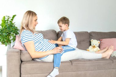 Hamile bir kadın en büyük oğluna sarılır. Seçici odaklanma. Aşk.