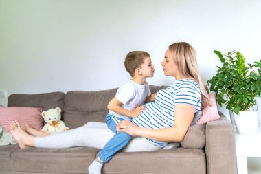 Hamile bir kadın en büyük oğluna sarılır. Seçici odaklanma. Aşk.