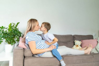 Hamile bir kadın en büyük oğluna sarılır. Seçici odaklanma. Aşk.