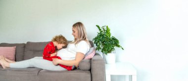 Hamile bir kadın en büyük kızına sarılır. Seçici odaklanma. Aşk.