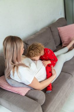 Hamile bir kadın en büyük kızına sarılır. Seçici odaklanma. Aşk.