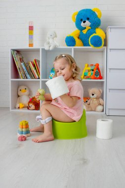 Lazımlıkta oturan çocuk. Yürüyen çocuk lazımlık eğitimi almış..
